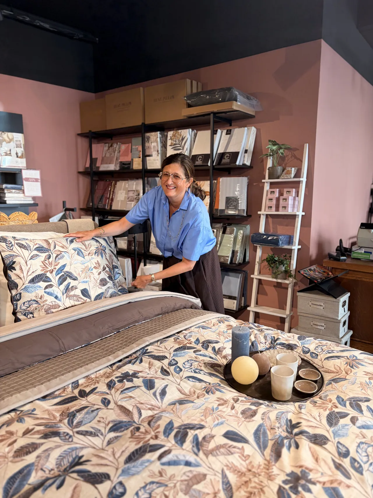 Brigitte bij het opgemaakte bed in de Kado winkel