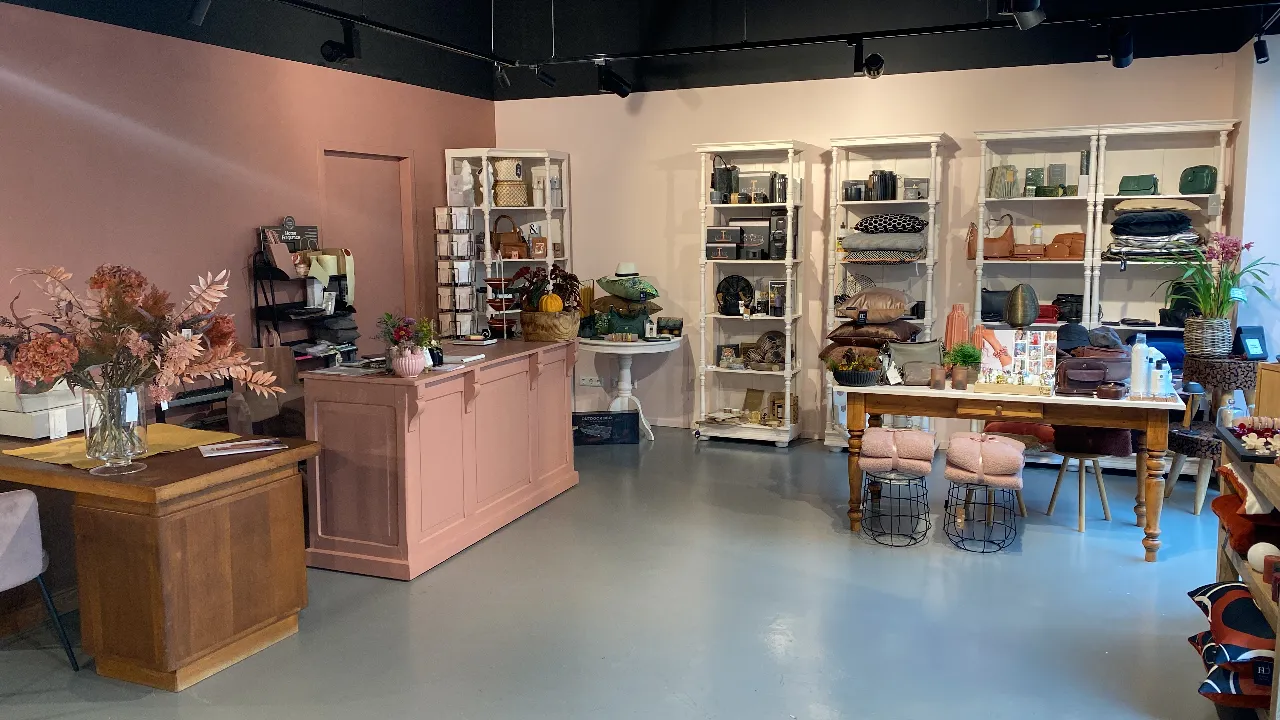 De Kado winkel met roze toonbank, leren tassen, kussens en woonaccessoires